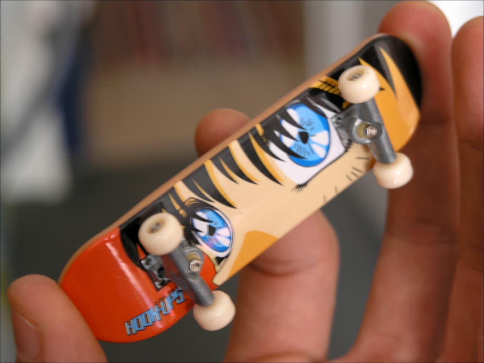 A close-up fingerboard deck setup on a work surface.