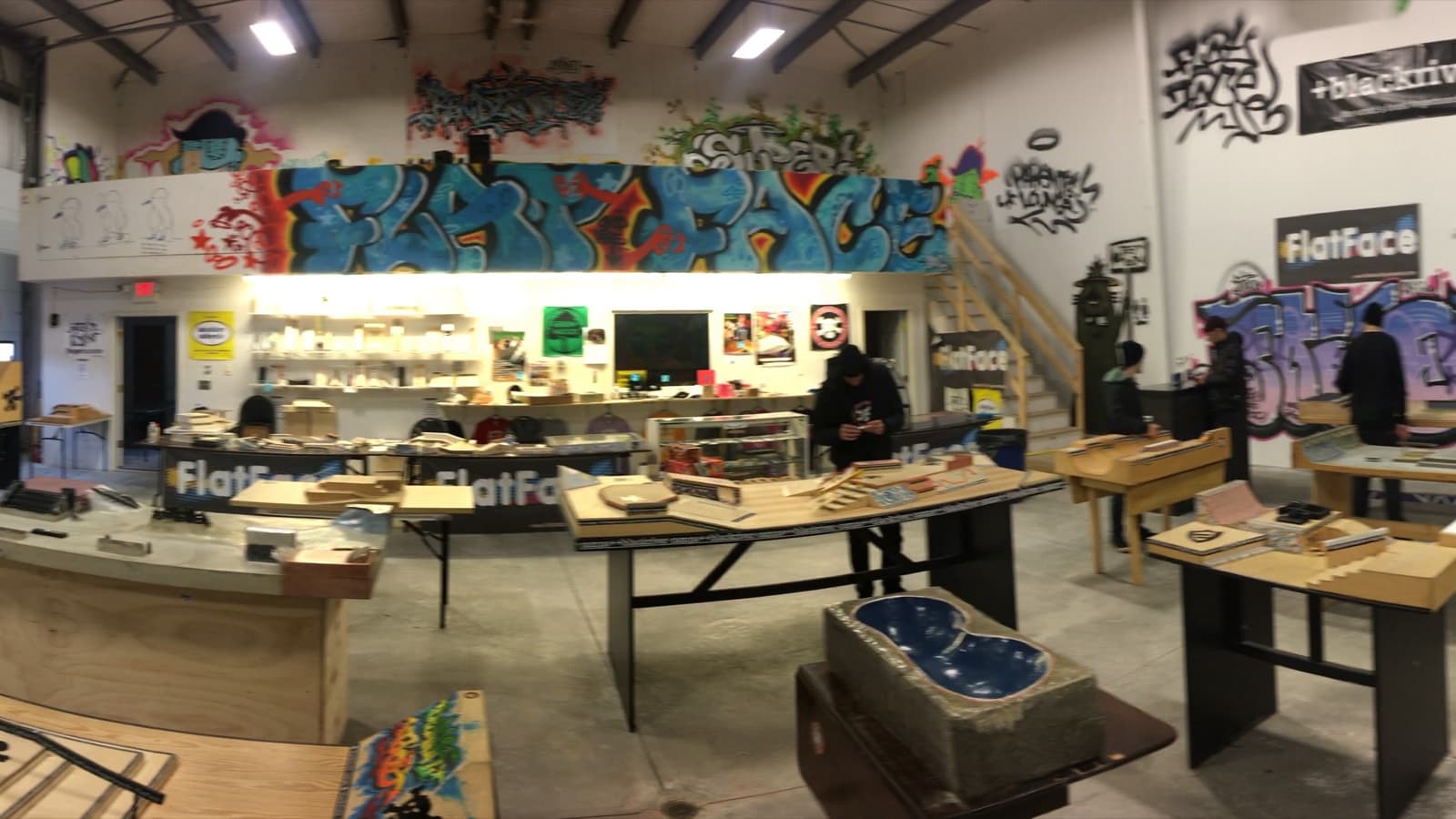 Inside the graffiti-covered FlatFace HQ, with fingerboard park tables set up across the floor.