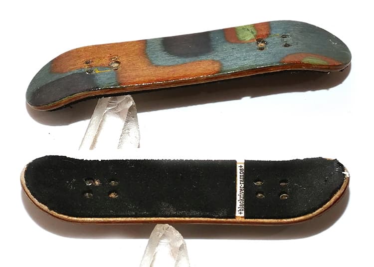 A worn early wooden fingerboard from the FlatFace museum collection, shown top and bottom.